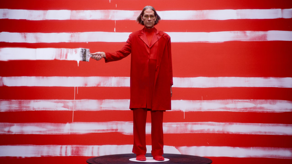 image from Jaguar's website showing a man in a red suit painting white stripes across the image