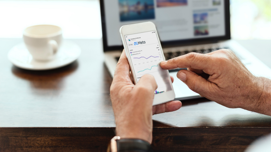 google ads agency birmingham. Image shows a person holding a smart phone with Meta Ads interface.